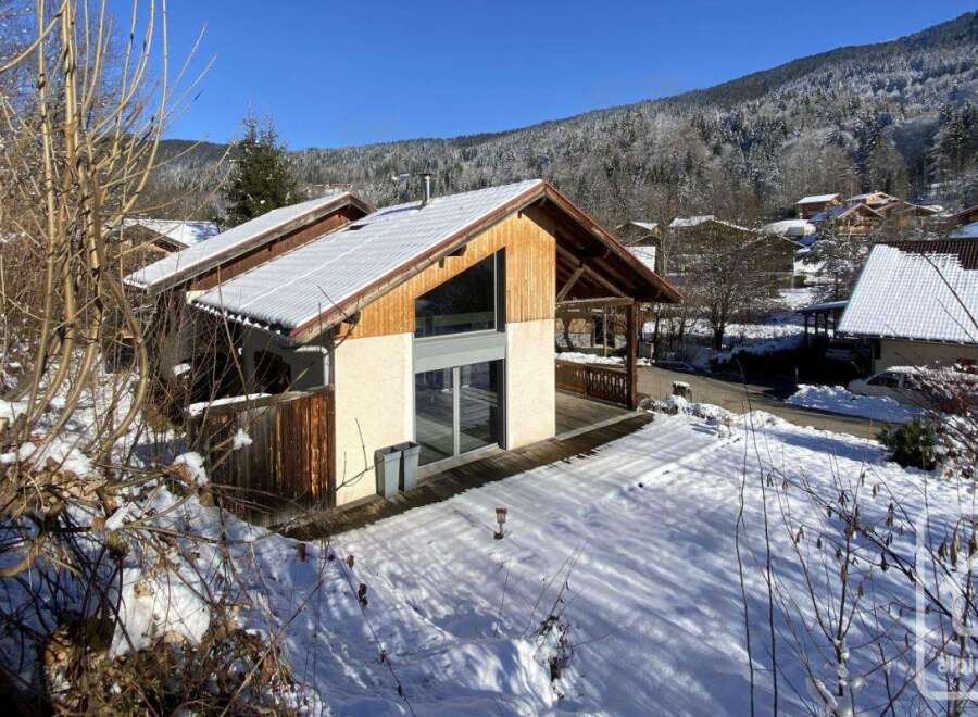This stunning chalet boasts a modern design with large windows offering breathtaking mountain views.