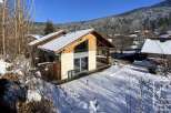 This stunning chalet boasts a modern design with large windows offering breathtaking mountain views.