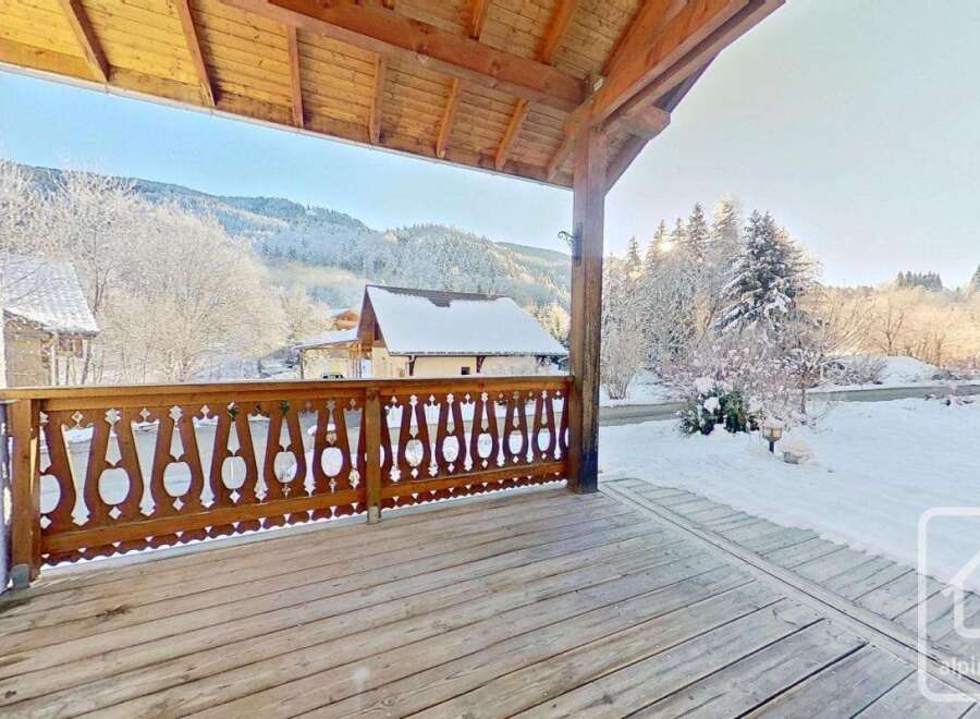 This stunning property boasts a spacious wooden deck, perfect for enjoying the breathtaking mountain views.