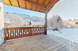 This stunning property boasts a spacious wooden deck, perfect for enjoying the breathtaking mountain views.