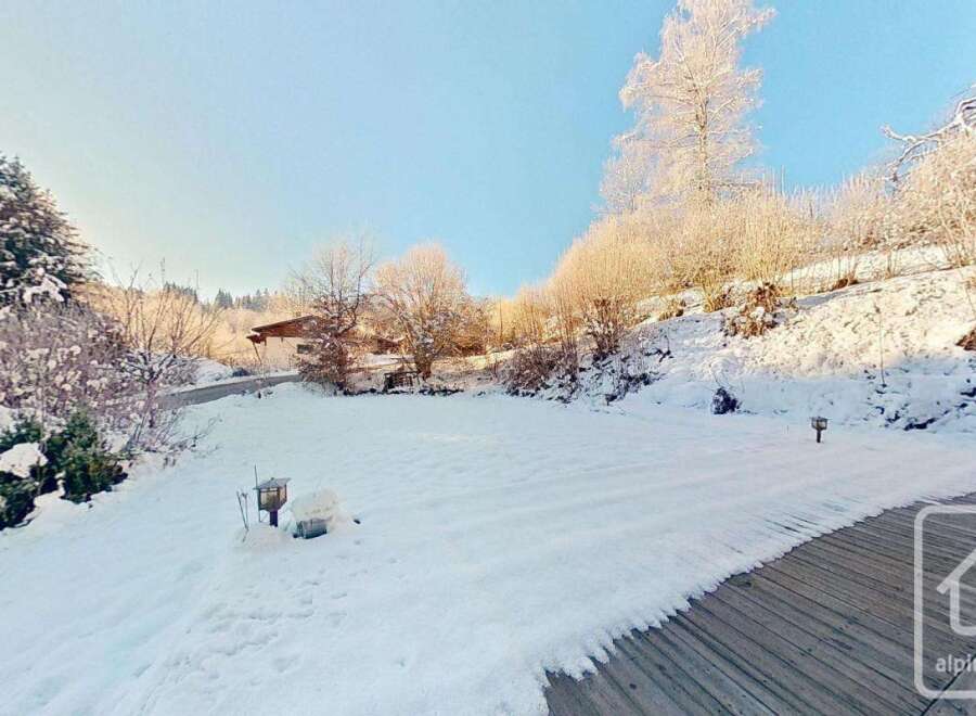This stunning property boasts a spacious, snow-covered backyard perfect for winter recreation, complete with charming outdoor lighting.