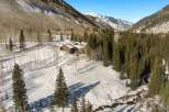 This secluded mountain home boasts stunning views and a tranquil setting nestled amongst snow-covered evergreens.