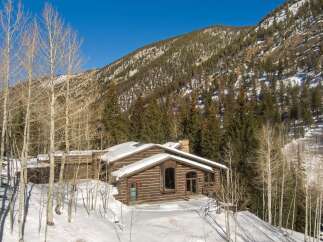 This stunning log cabin nestled in the Colorado mountains offers breathtaking views and luxurious amenities.