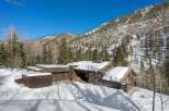This stunning log cabin nestled in the Colorado mountains boasts a spacious design with a large garage and expansive windows offering breathtaking views.