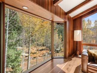 This stunning property boasts expansive windows showcasing breathtaking views of the surrounding aspen trees and mountain landscape.