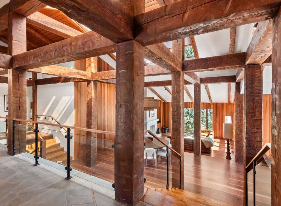 This stunning home boasts a breathtaking open-concept design with massive reclaimed wood beams creating a dramatic and inviting atmosphere.