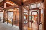 This stunning home boasts a breathtaking open-concept design with massive reclaimed wood beams creating a dramatic and inviting atmosphere.