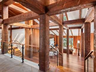 This stunning home boasts a breathtaking open-concept design with massive reclaimed wood beams creating a dramatic and inviting atmosphere.