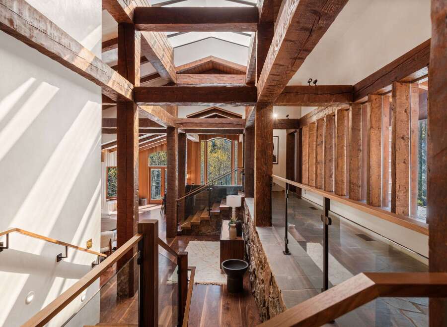 This stunning home boasts a grand entrance with exposed wooden beams, creating a warm and inviting atmosphere.