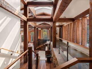 This stunning home boasts a grand entrance with exposed wooden beams, creating a warm and inviting atmosphere.