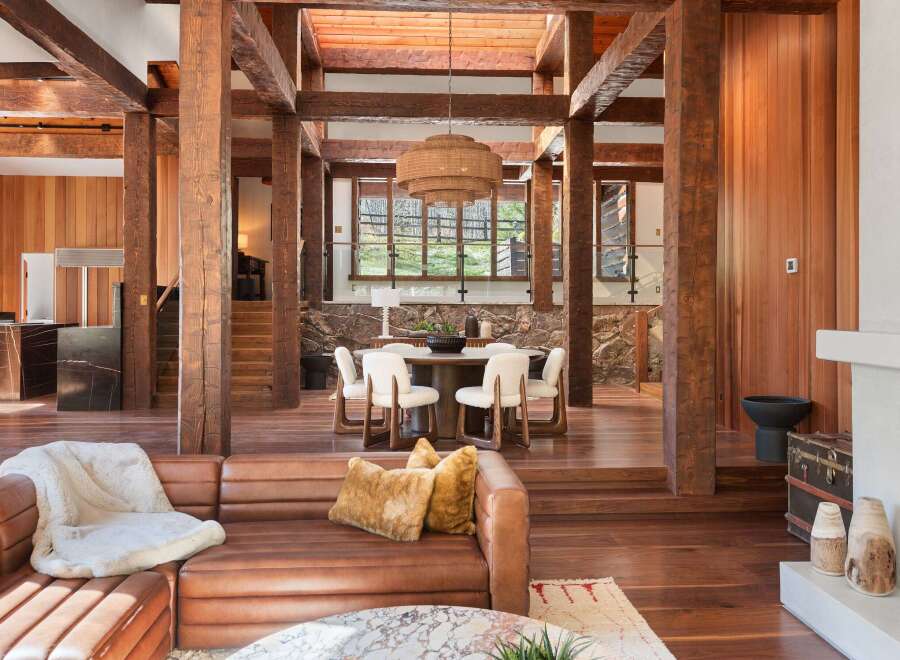 This stunning home boasts a spacious open floor plan with exposed wooden beams, creating a warm and inviting atmosphere.