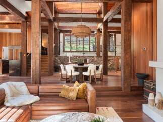 This stunning home boasts a spacious open floor plan with exposed wooden beams, creating a warm and inviting atmosphere.