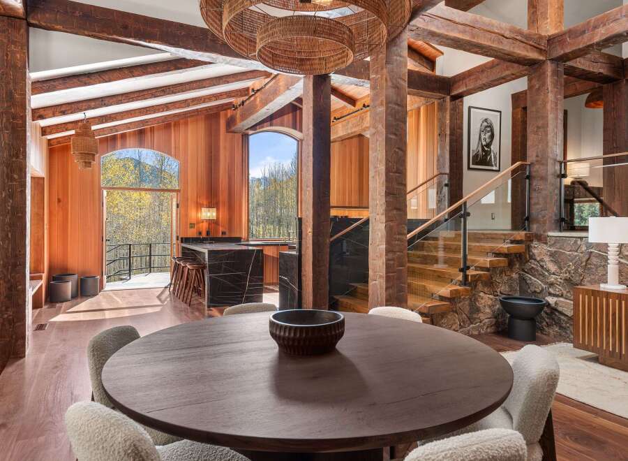 This stunning home boasts a spacious open floor plan with exposed wooden beams, creating a warm and inviting atmosphere.