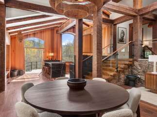 This stunning home boasts a spacious open floor plan with exposed wooden beams, creating a warm and inviting atmosphere.