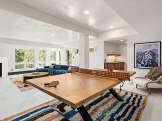 This stunning property boasts a spacious recreation area with a custom-made ping pong table, perfect for entertaining guests.
