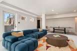 This stunning basement boasts a spacious, open layout perfect for entertaining, featuring a plush sectional sofa and a stylish coffee table.