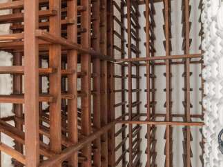 This stunning wine cellar boasts two expansive wooden racks, offering ample storage for an impressive collection.