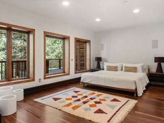 This stunning bedroom boasts a minimalist design with large windows offering breathtaking views of the surrounding landscape.