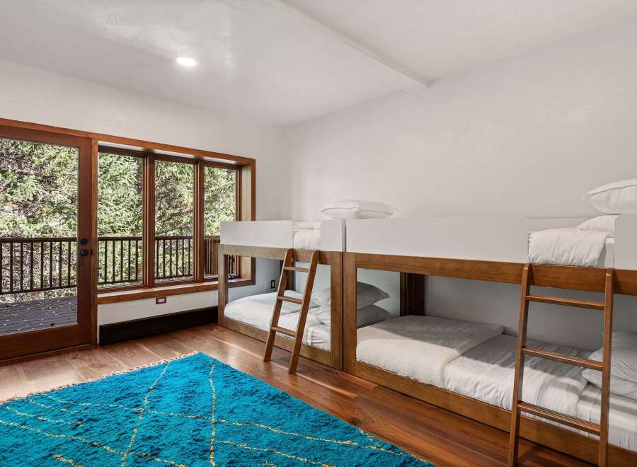 This stunning bedroom features two sets of modern bunk beds, perfect for families or groups.