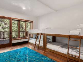 This stunning bedroom features two sets of modern bunk beds, perfect for families or groups.