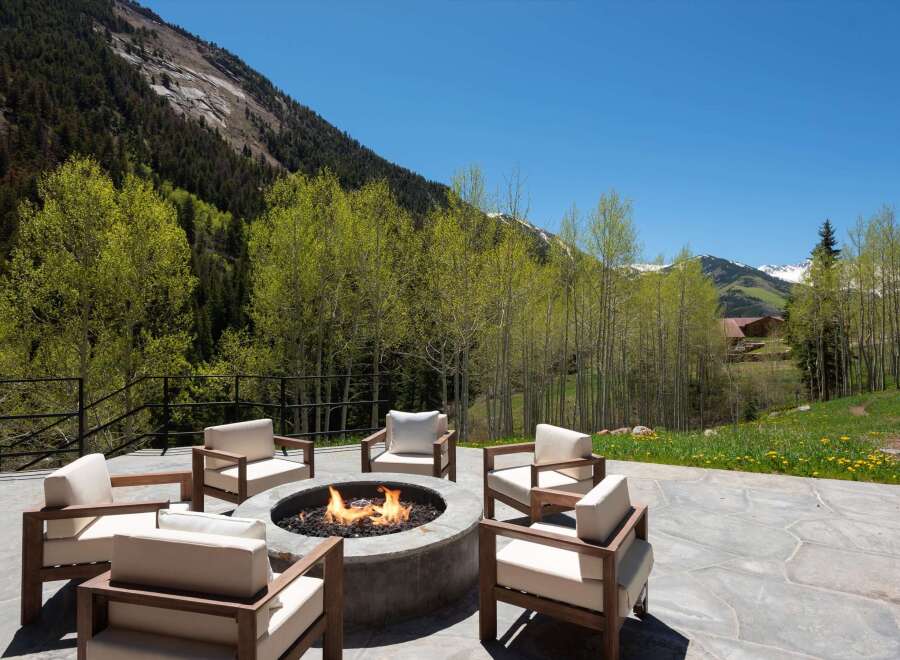 Luxury mountain retreat with a stunning outdoor patio featuring a fire pit and comfortable seating.