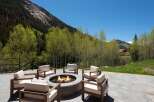 Luxury mountain retreat with a stunning outdoor patio featuring a fire pit and comfortable seating.