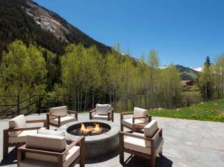 Luxury mountain retreat with a stunning outdoor patio featuring a fire pit and comfortable seating.