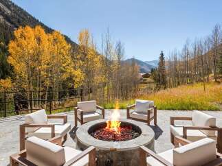 Luxury mountain retreat with a stunning outdoor fire pit perfect for enjoying the crisp autumn air.