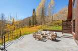 This stunning property boasts a spacious patio with a fire pit, perfect for enjoying the breathtaking mountain views.