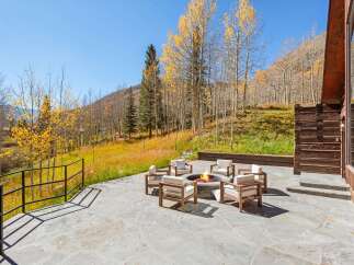 This stunning property boasts a spacious patio with a fire pit, perfect for enjoying the breathtaking mountain views.