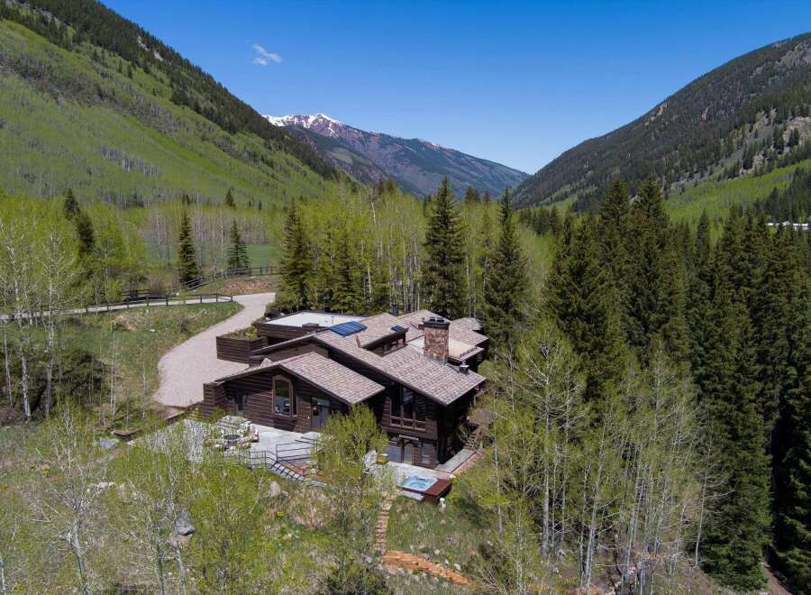Nestled in a mountain valley, this secluded log home boasts stunning views and a private hot tub.