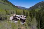 Nestled in a mountain valley, this secluded log home boasts stunning views and a private hot tub.