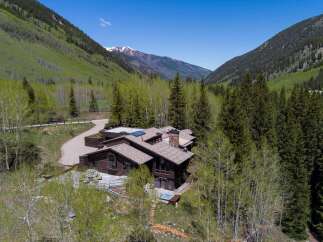 Nestled in a mountain valley, this secluded log home boasts stunning views and a private hot tub.
