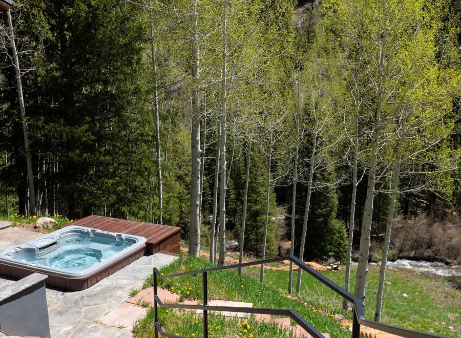 Luxury mountain getaway with a private hot tub overlooking a serene forest landscape.