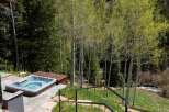 Luxury mountain getaway with a private hot tub overlooking a serene forest landscape.