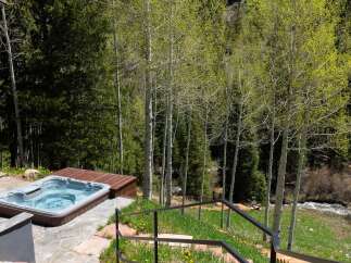 Luxury mountain getaway with a private hot tub overlooking a serene forest landscape.