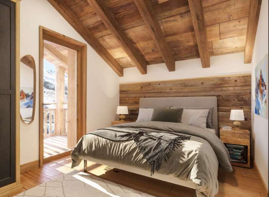 Cozy chalet bedroom with wooden beams, ensuite bathroom, and balcony access.