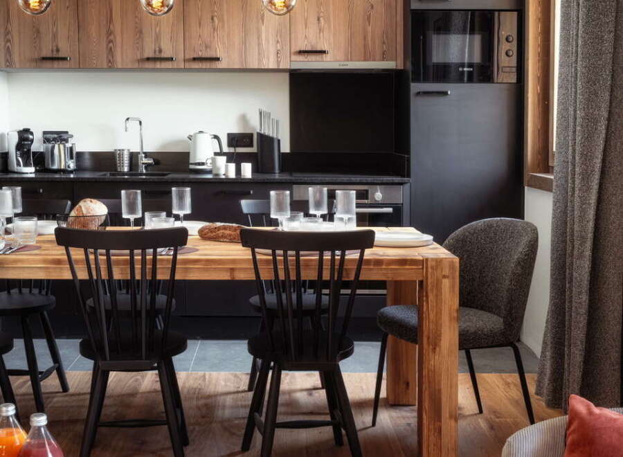 This stunning apartment boasts a modern kitchen with sleek black appliances and rustic wooden cabinets, perfect for preparing delicious meals.