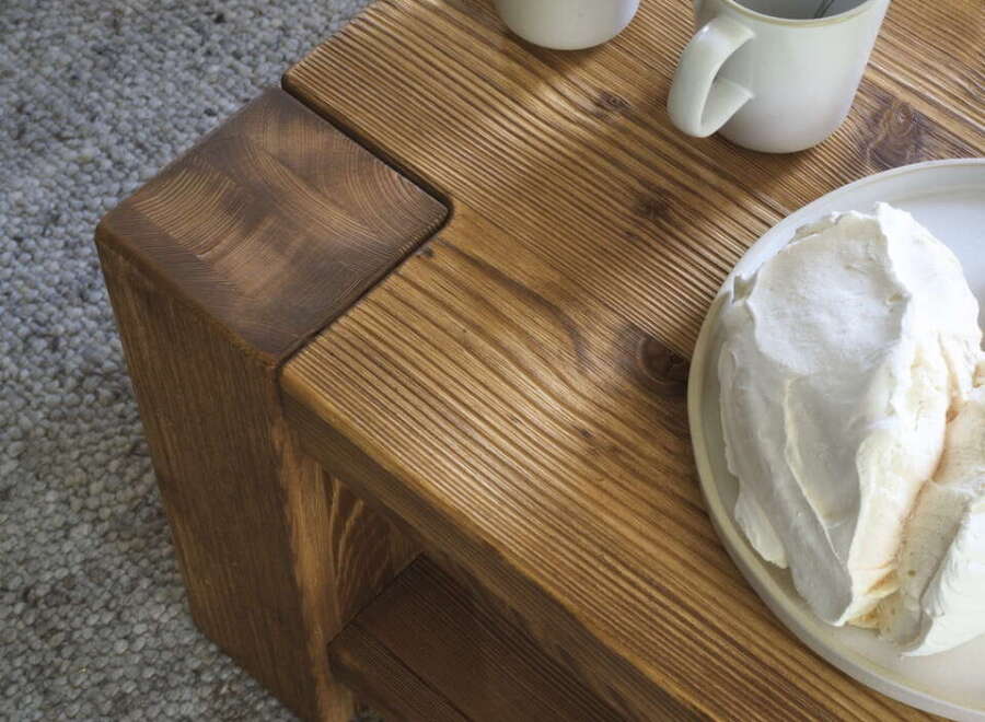 Rustic wooden coffee table with a lower shelf, perfect for a cozy living room.