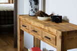 Rustic wooden console table with three drawers, perfect for entryway storage.