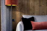 Cozy living room with a light grey corduroy sofa, complemented by plush red and black velvet cushions.