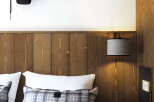 Cozy up in our rustic-chic room, featuring a plush bed with plaid accents and a unique longhorn skull wall decoration.
