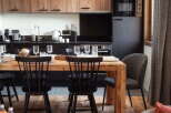 This stunning apartment boasts a modern kitchen with sleek black appliances and rustic wooden cabinets, perfect for preparing delicious meals.