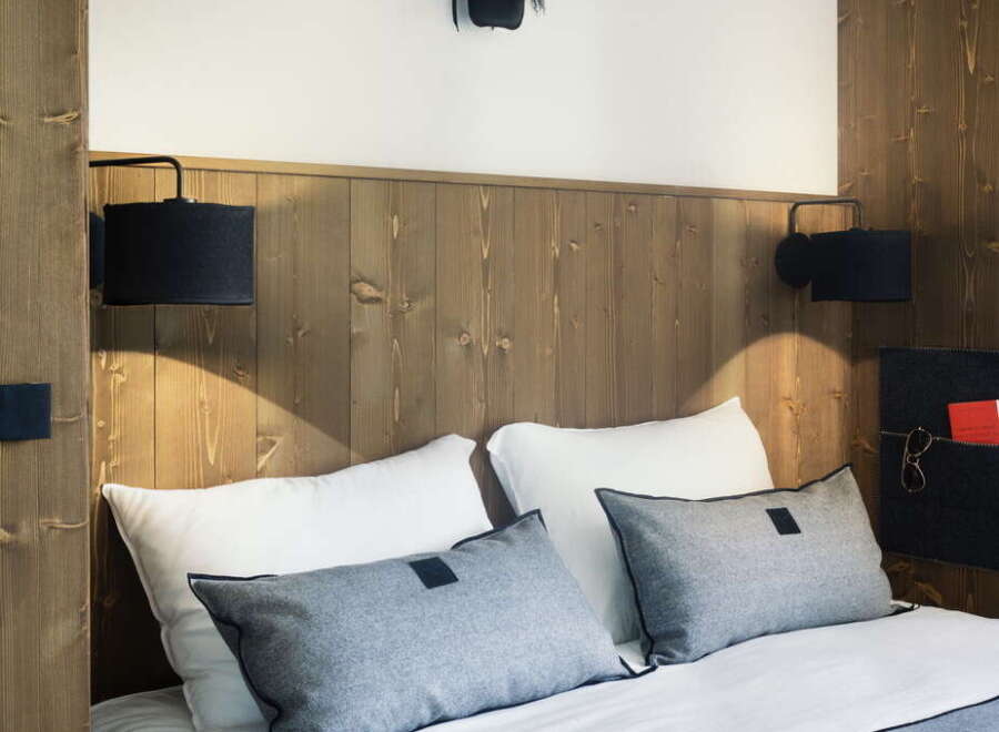 Cozy up in this charming hotel room, featuring a comfortable double bed with plush pillows and a soft throw blanket.