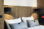 Cozy up in this charming hotel room, featuring a comfortable double bed with plush pillows and a soft throw blanket.