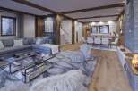 This stunning chalet boasts an open-plan living area with a cozy fireplace, perfect for relaxing after a day on the slopes.