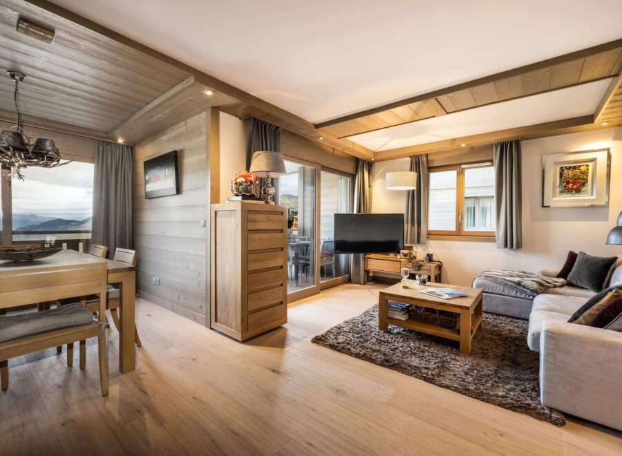 This stunning apartment boasts a spacious open-plan living area with floor-to-ceiling windows offering breathtaking mountain views.