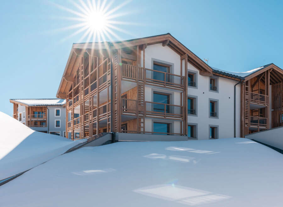 Luxury apartments nestled in a snowy mountainside, offering breathtaking views and easy access to winter activities.
