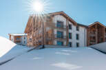 Luxury apartments nestled in a snowy mountainside, offering breathtaking views and easy access to winter activities.