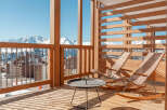 Relax and enjoy breathtaking mountain views from your private balcony, complete with comfortable rocking chairs and a stylish side table.